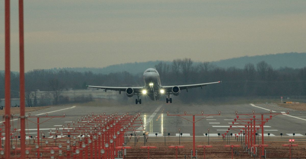A commercial airplane lands on a runway at Windsor Locks Airport, showcasing aviation precision.