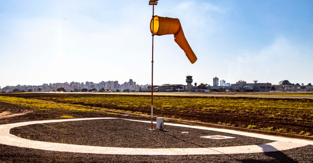 View of a windsock and control tower at Londrina airport highlighting aviation and communication.