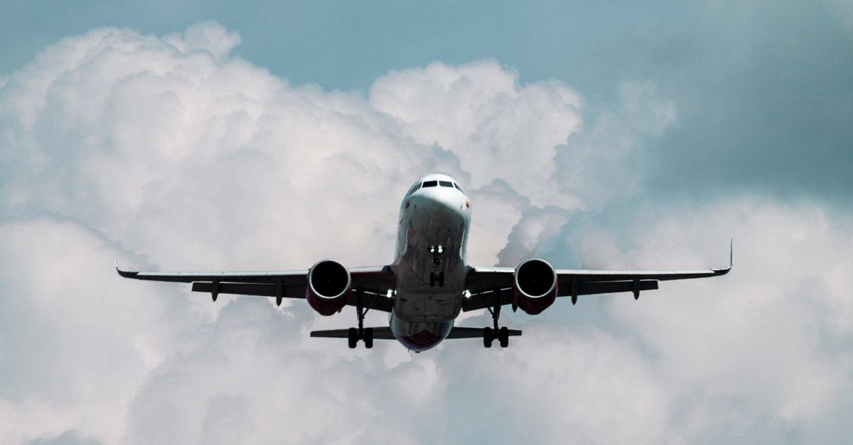 A commercial airplane approaching through a cloudy sky, showcasing aviation power.