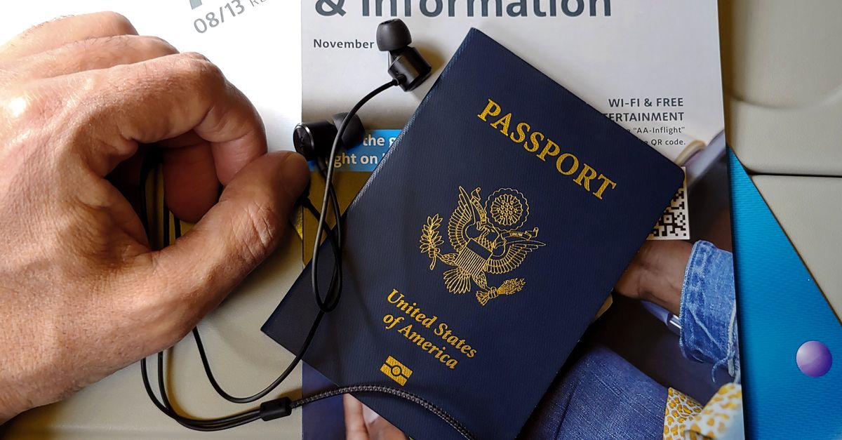 A US passport resting on airline seat travel essentials.