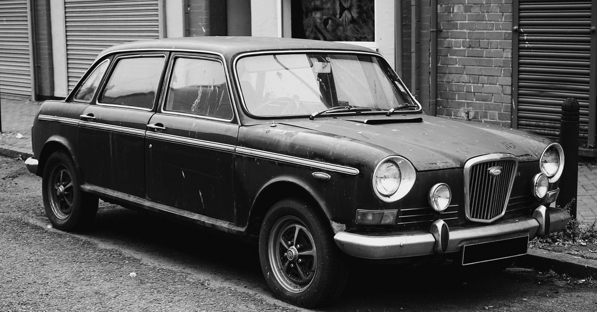 Monochrome image of a vintage car parked on a Liverpool street, capturing classic automotive design.