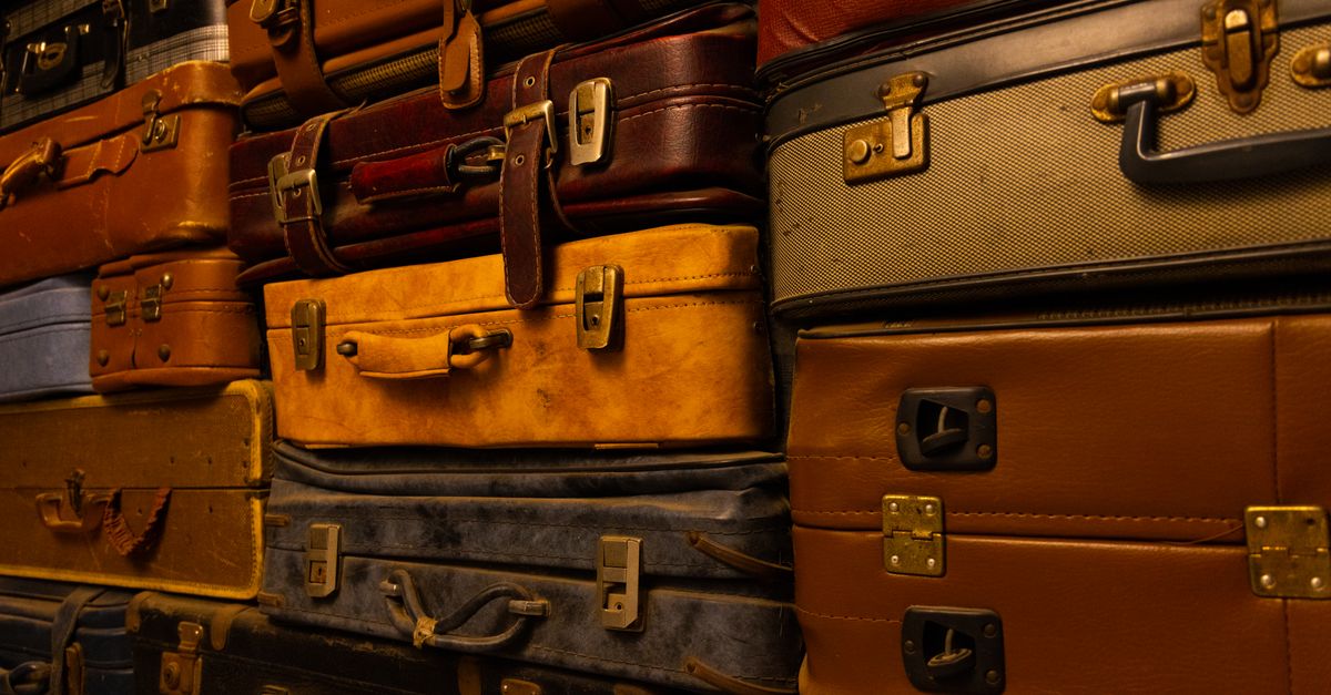 Stack of vintage leather suitcases piled against each other.