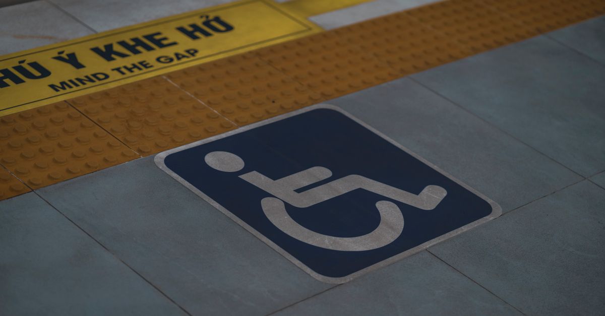 Close-up of handicap symbol and 'Mind the Gap' warning on a station platform.