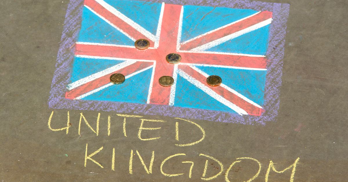 Colorful chalk drawing of the UK flag with coins on pavement, signifying currency and culture.