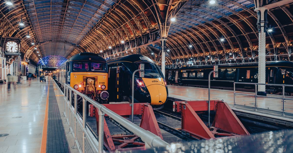 London's Paddington Station showcasing modern trains under its iconic roof archway.