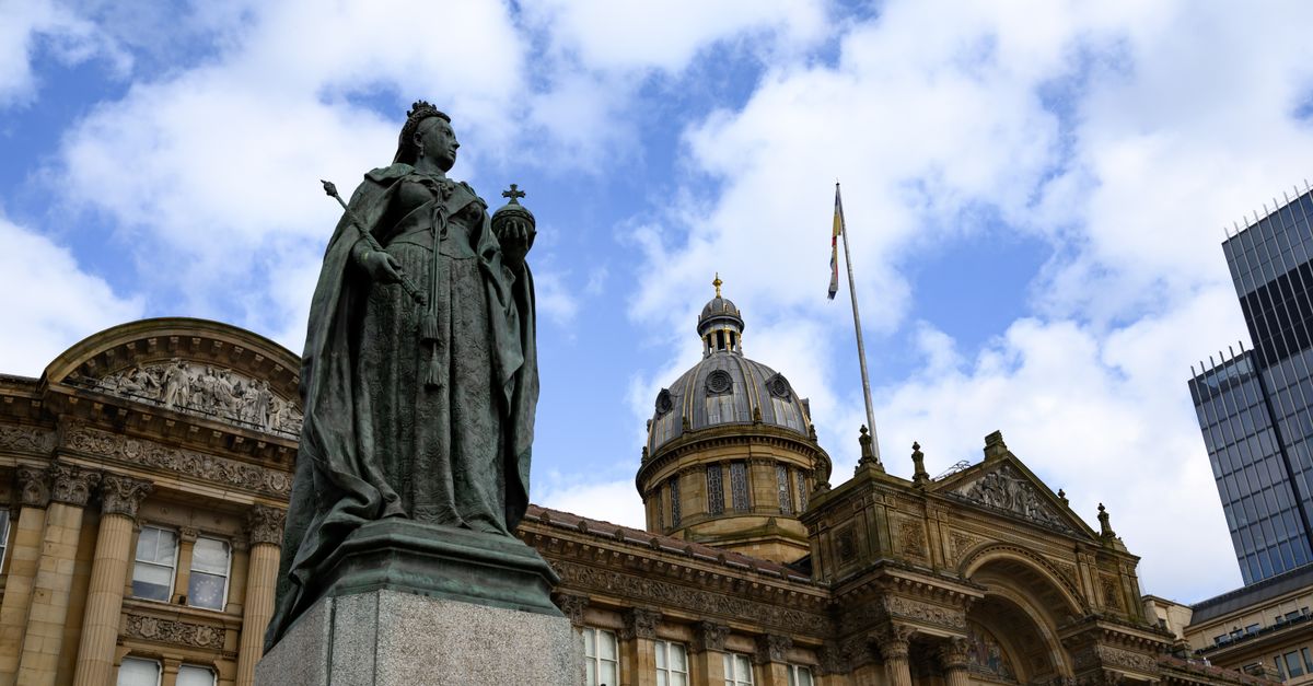 Statue of Queen Victoria outside Birmingham Council House with blue sky background.