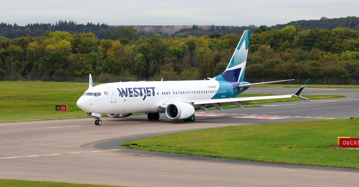 WestJet aircraft taxiing on a runway at a Scottish airport surrounded by lush greenery.