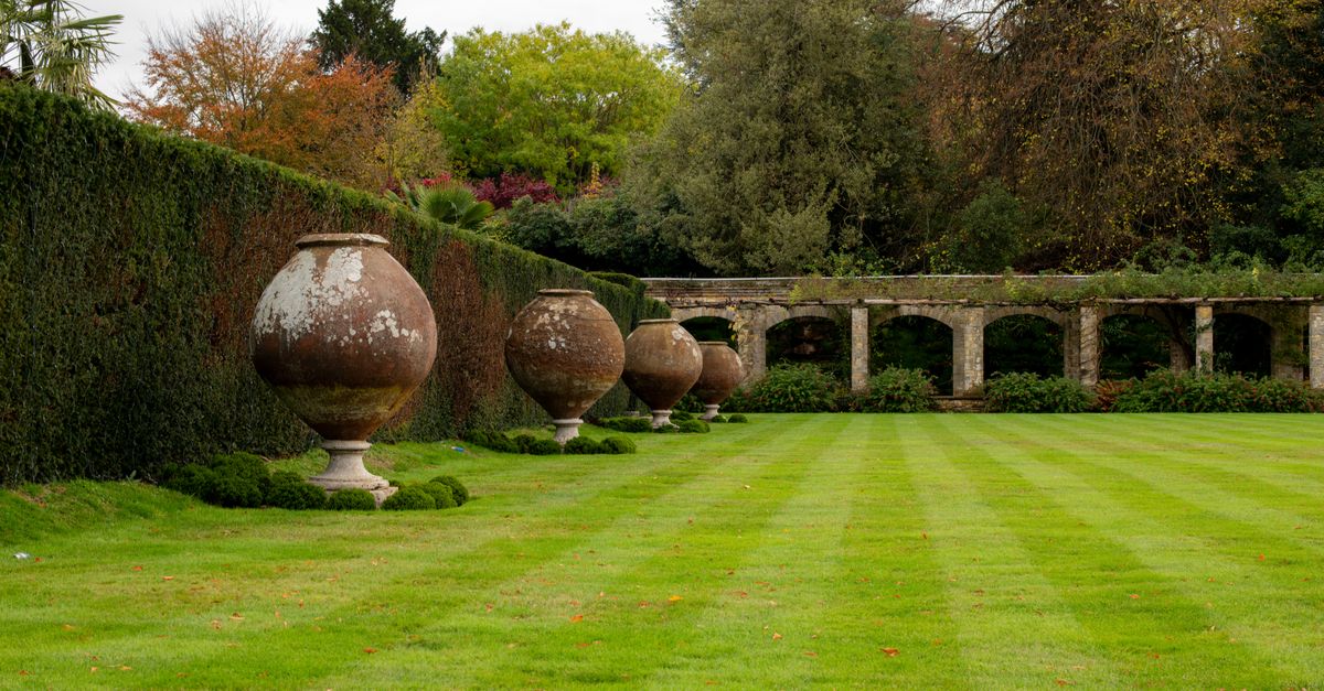 Beautiful garden with large stone urns in Hever Castle, England, showcasing classic English landscape architecture.