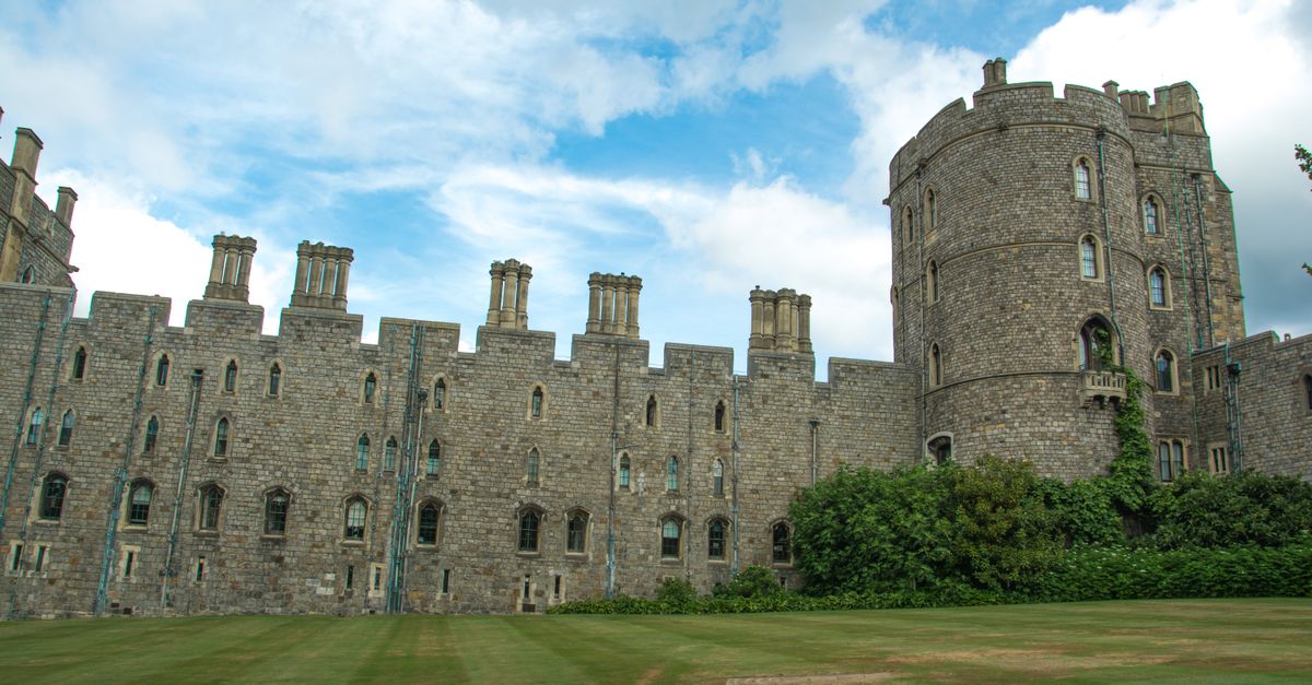 Windsor Castle's historic stone facade under a vibrant blue sky, showcasing its iconic turrets.