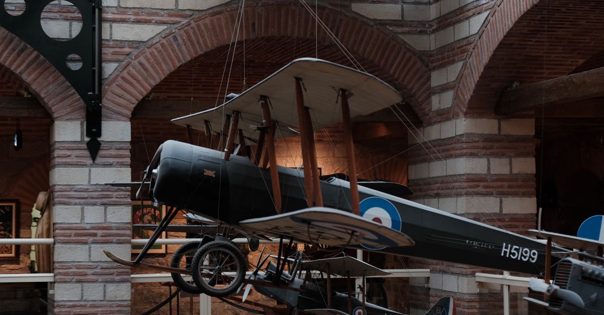 Vintage aircraft suspended in a museum, showcasing classic aviation history.