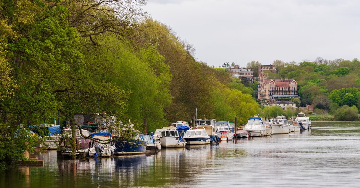 Peaceful riverside scene with boats and trees, capturing the essence of spring.