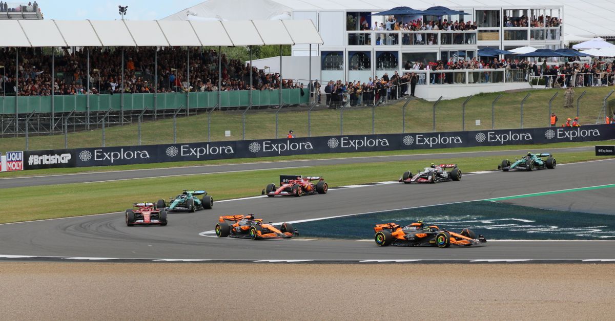 Thrilling car race at Silverstone Circuit with packed grandstands and vibrant crowd.
