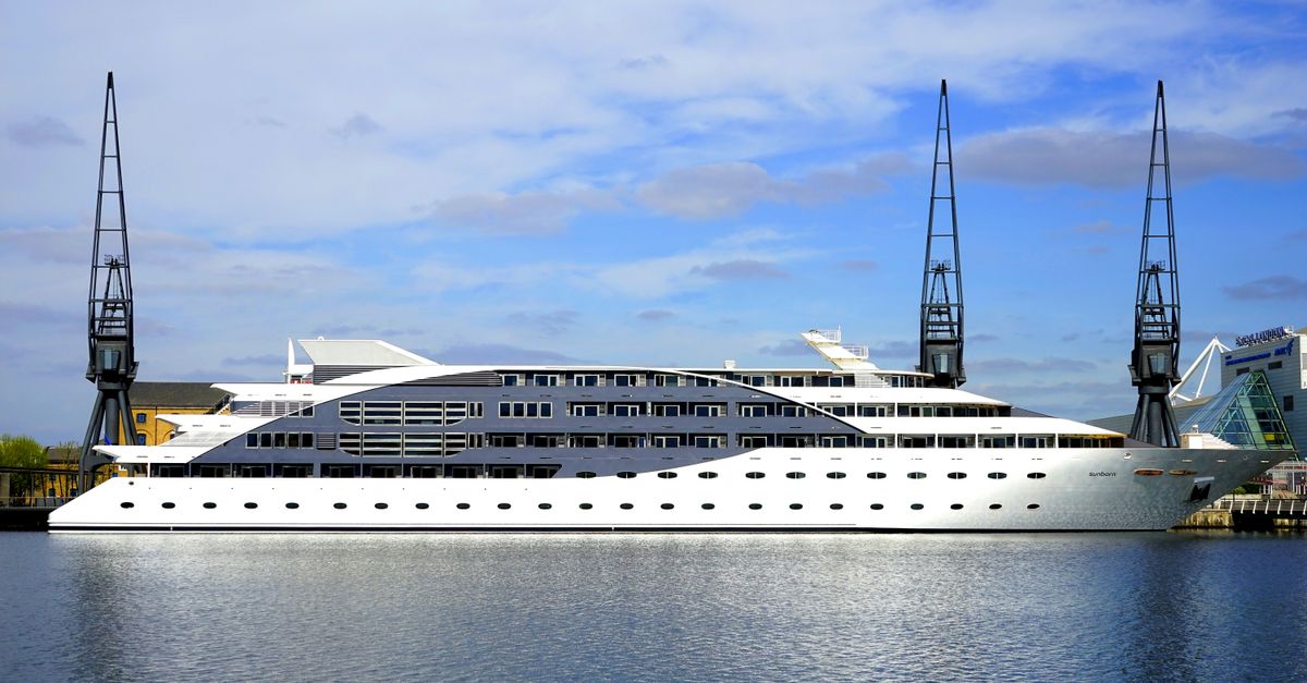 Stunning view of a luxury cruise ship docked at a modern harbor under a blue sky.