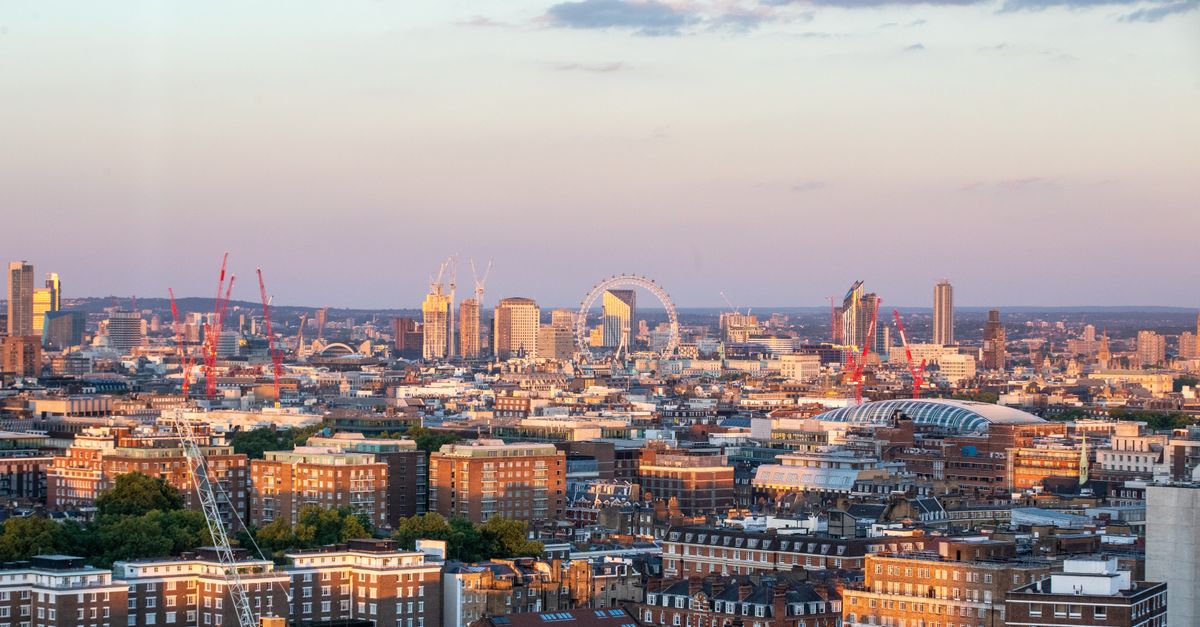 Aerial view of London's cityscape featuring the London Eye during sunset.